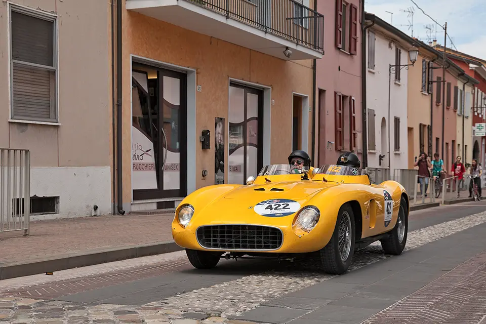 A yellow ferrari on a street in Italy