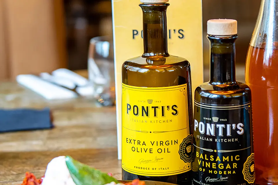 A close up view of a bottle of Ponti's Balsamic Vinegar and Extra Virgin Olive oil